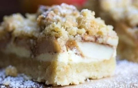 Apfel-Cheesecake mit Walnuss-Streuseln und Karamellsauce auf einem Teller