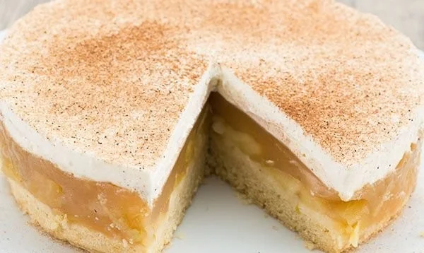 Leckere Apfel-Sahne-Torte auf einem Teller mit frischen Äpfeln