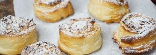 Apfel-Zimt-Blätterteigschnecken frisch aus dem Ofen mit Zimt und Äpfeln