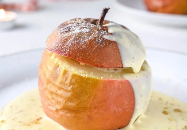 Bratapfel mit Vanillesoße auf einem Teller serviert