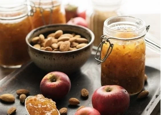 Leckere Bratapfelmarmelade in einem Glas mit Äpfeln und Gewürzen