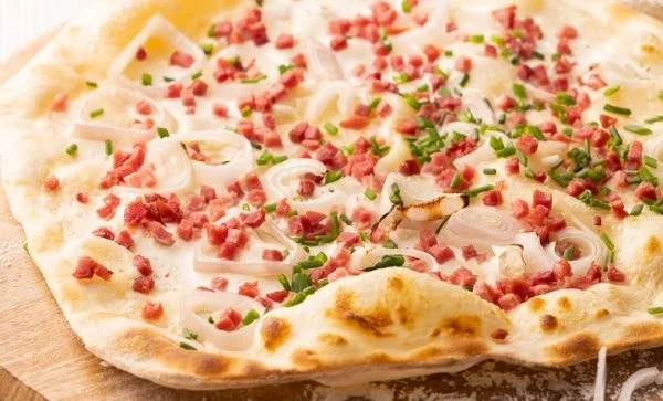 Delikater Flammkuchen mit frischen Zutaten und knusprigem Boden.