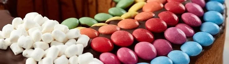 Bunter Geburtstags-Regenbogenkuchen mit verschiedenen Schichten und Zuckerguss.