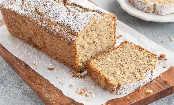 Leckerer Nusskuchen frisch aus dem Ofen mit Nüssen und Puderzucker.