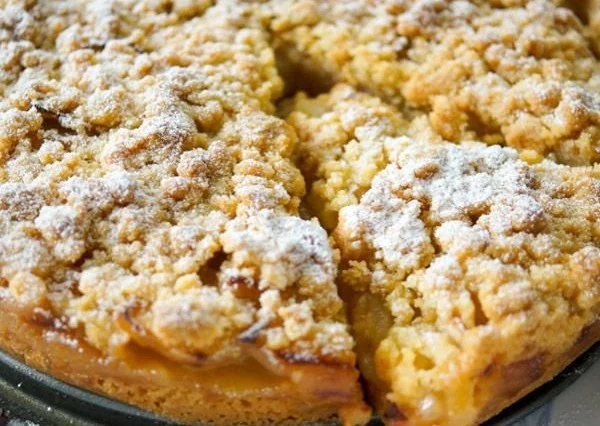Omas traditioneller Apfelkuchen mit Streuseln frisch gebacken auf einem Teller.