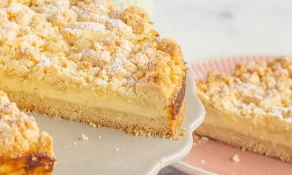 Streuselkuchen mit Pudding auf einem Teller serviert